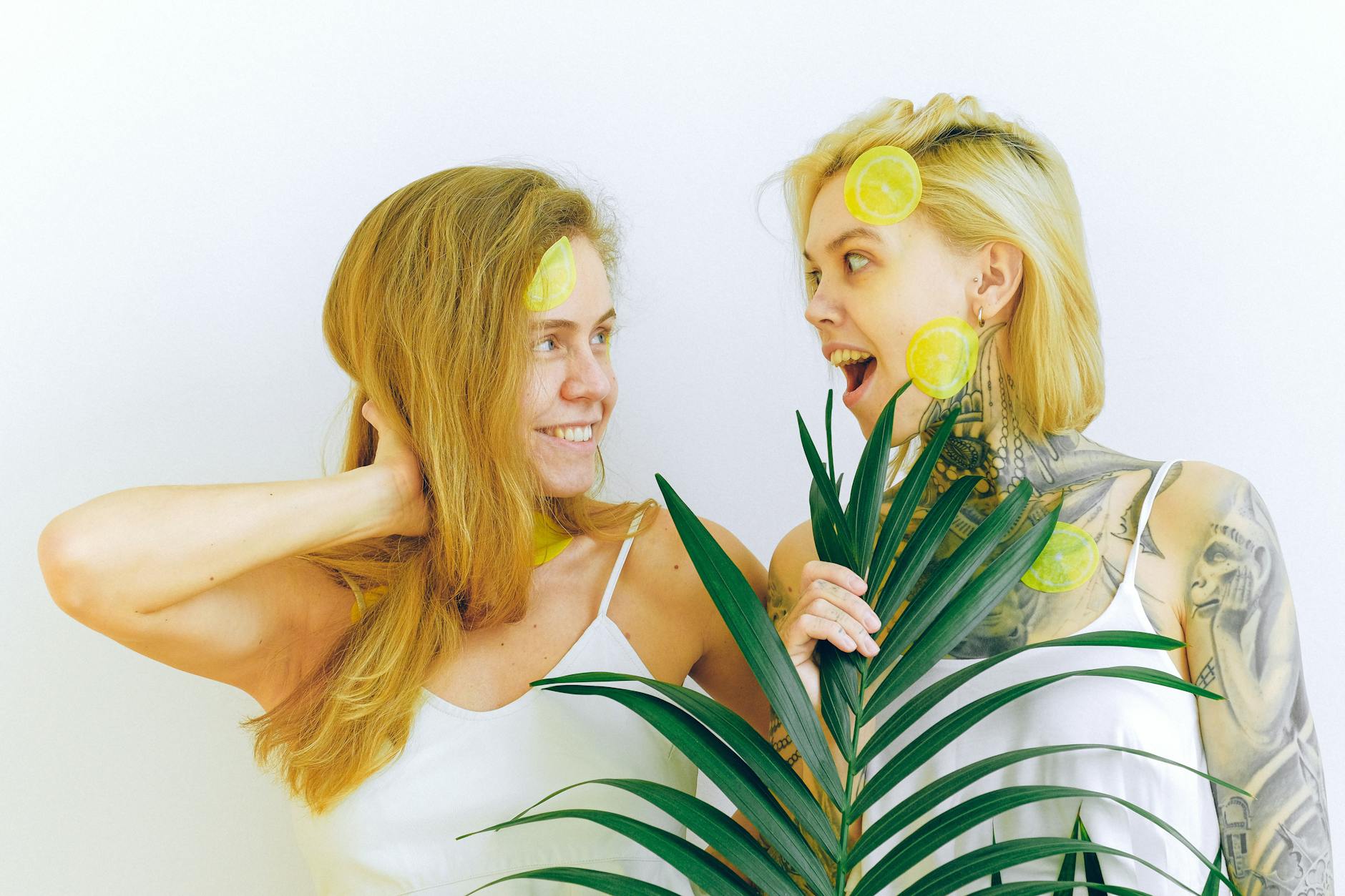 Two women smiling with fresh lemons, expressing joy and connection