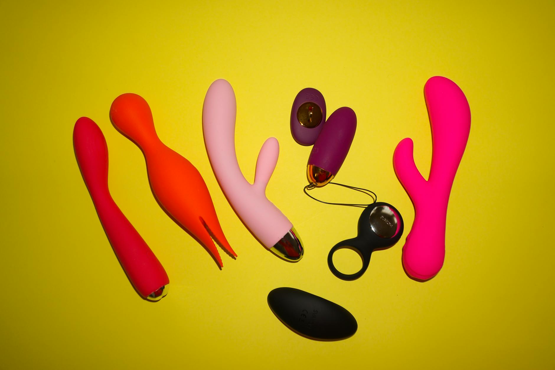 Hand holding a vibrator against a purple background, representing intentional self-pleasure